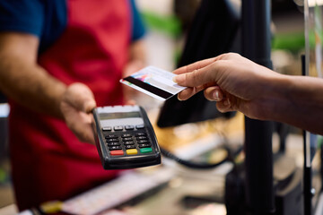 Close up of woman paying with credit card in supermarket.