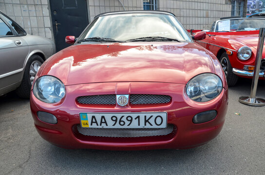 Sleek red 1999 Rover MG F, distinctive mid engined British roadster showcasing smooth rounded lines twin headlamps and the classic MG grille with its octagon badge