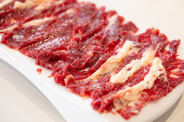 angle view dish of raw fatty beef slices at horizontal composition