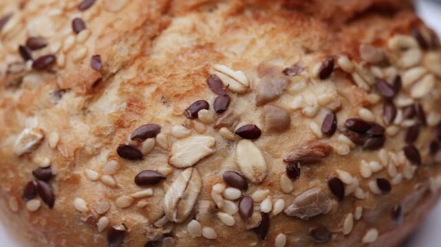 Seeded bread bun rotating in detailed macro seamless loop for culinary stock use
