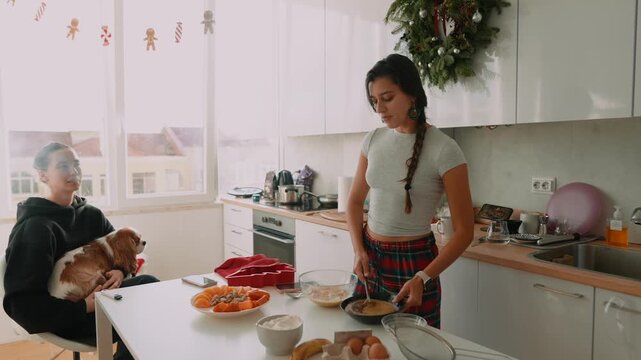 Two friends enjoy cozy morning meal together in kitchen