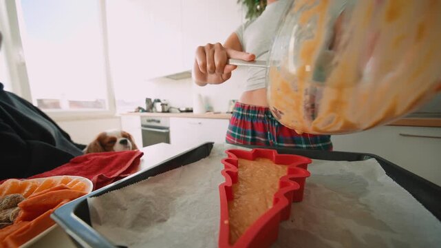 Home baker skillfully filling treeshaped mold with smooth batter