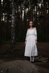Woman in Vintage White Off-Shoulder Dress amidst Pine Forest