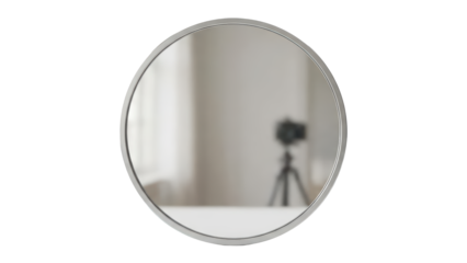 Stylish round mirror with silver frame reflecting a blurred camera setup for content creation isolated