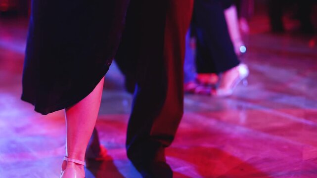 Tangueros couples dancing traditional latin argentinian dance milonga in a ballroom, tango salsa bachata kizomba lesson in red and purple lights, rehearsal evening dance school class festival