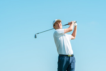 Male golfer playing golf on a golf course (smiling, tee shot, golf competition)