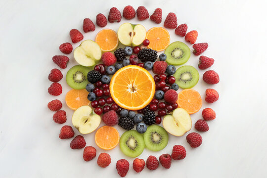 Fresh fruits including banana, apple, strawberry, kiwi, and blueberry arranged in a colorful circular pattern. Perfect for healthy food, nutrition, wellness, and culinary concepts.