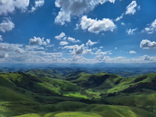 Obraz premium Green Hills Under Blue Sky with Clouds