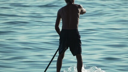 Paddleboarding, man, water, enjoying calm sea waves on a summer evening
