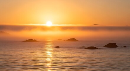 Obraz premium Golden Hour Ocean Sunrise with Fog and Coastal Rocks Reflecting the Warm Light