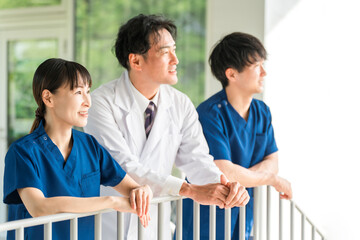 Male and female doctors, nurses, medical staff and technicians taking a break outside the hospital
