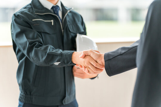 握手をする作業着姿の男性ビジネスマン,作業員
