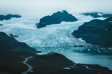 Glacial landscape with ice-covered mountains and a calm lake surrounded by rugged terrain
