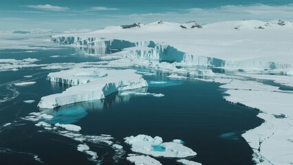 Aerial view of icy Arctic landscape with floating icebergs and glacier formations in a cold, remote region