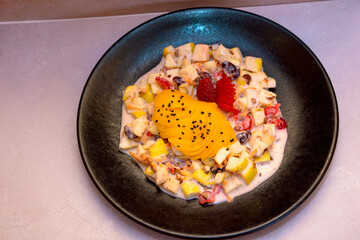 Imagen cenital de un plato de ensalada de frutas con crema estilonavideña