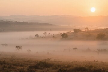 Fototapeta premium Misty sunrise over a serene landscape with rolling hills and scattered trees