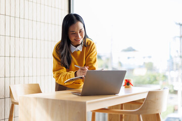 Asian casual business woman using laptop to working about growth finance report of new startup project.