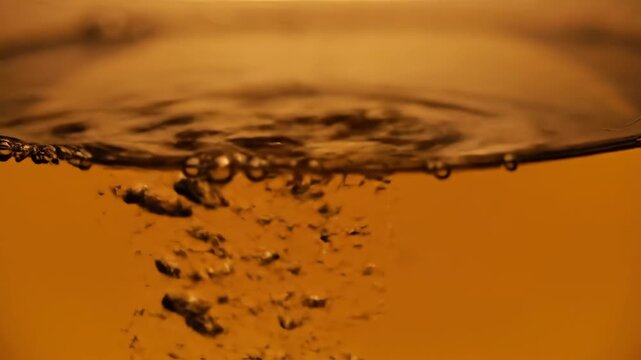 Pouring amber liquid with bubbles forms interesting shapes