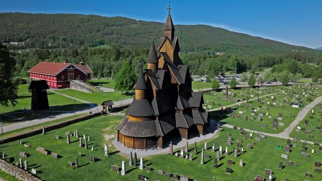 High tilt reveal drone shot of Bygdoy Historic Burial Ground by Norsk Folkemuseum. Summer morning aerial for tourism and lifestyle showing paths, trees and graves layout.
