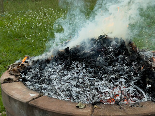 dangerously hot orange and red flames with dense black smoke consuming wood and embers