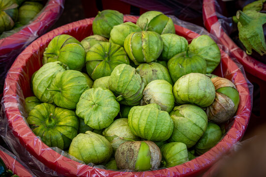Bushel filled with fresh tomatillo  on display at a farm market