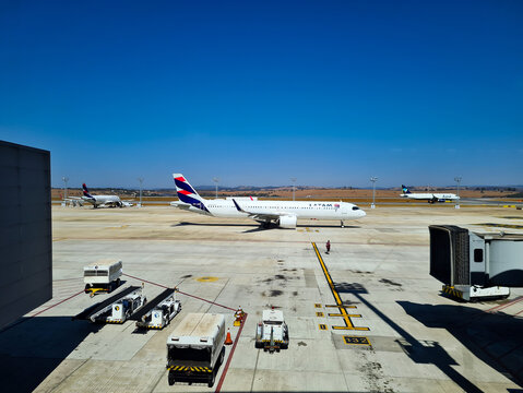 Planes taxiing on the runway in front of the passenger terminal at Confins Airport in Minas Gerais, Brazil.