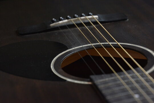 A close-up image of guitar strings against a black background