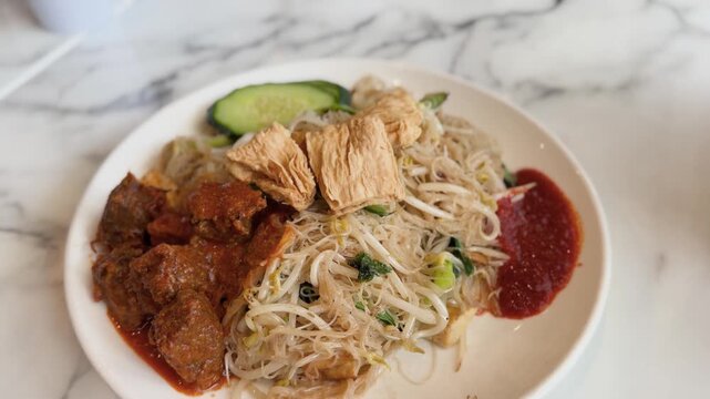 A plate of vegetarian mee hoon noodles served with flavourful mock mutton at a Malaysian restaurant in New Zealand. 