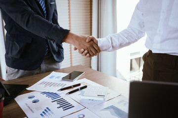 Business team analyzing financial charts and using a calculator during a meeting.