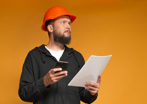 a frightened worker with documents and a phone in his hands - Powered by Adobe