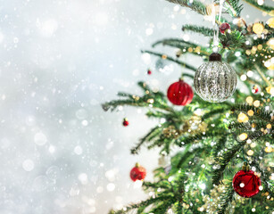 Christmas tree with red decorations on light background with bokeh, sparking, glowing. Merry Christmas and Happy New Year greeting card. Xmas and Winter holidays. Christmas banner