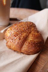 Fresh pastry sits on a wooden table with coffee nearby