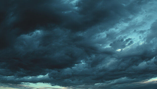Dramatic Low Angle View of Dark Stormy Clouds in shades of Blue and Black