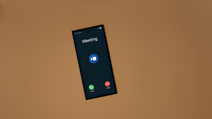 A smartphone screen displays a video meeting interface on a brown background, symbolizing modern remote communication and collaboration in a professional setting.