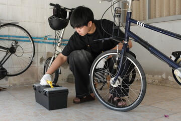 Authentic young tomboy repairing a flat bicycle tire in a garage. Independent female mechanic fixing a bike wheel with tools. DIY maintenance and empowerment concept.