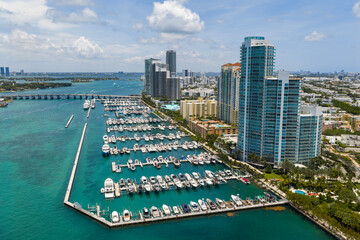 Luxury yacht docked at Miami marina. Aerial view of coastline in Miami. Sailboat cruising along the...