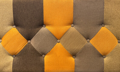 Close up of colorful upholstered panel or sofa cushion in black, grey, and yellow color with beads and button. Suitable for upholstery sofa. Seamless background texture.