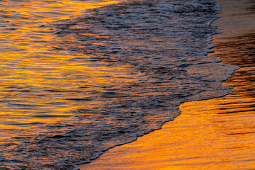 夕日に染まる波打ち際