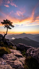 Obraz premium Scenic mountain vista with a lone tree during a sunset