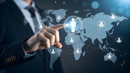 Businessman hand pointing at a glowing human icon on a digital world map representing global networking, human resource management, and international business connection