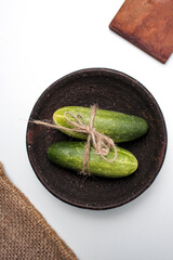 Aesthetic still life center of cucumber on burlap and white background with symmetrical composition type