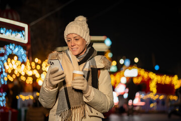 Woman smiling using phone at christmas market