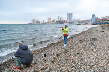 Two Russian women 50 and 60 years old spend spring by the sea in Vladivostok as one photographs the other enjoying calm mindful outdoor moments