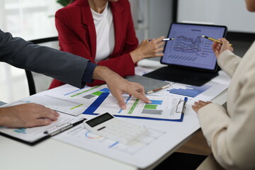 Business people analyzing financial charts and graphs using calculator and tablet.