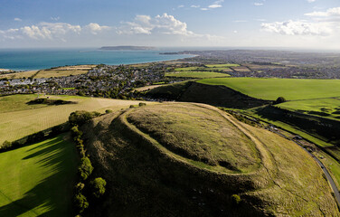 Chalbury early Iron Age hillfort. Single rampart strategic site. Enclosed depressions are hut platforms and storage pits. View S over Weymouth Bay