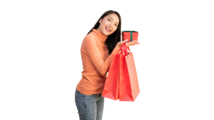 Happy Asian woman holding red shopping bags and gift box for Christmas and New Year holiday shopping.
