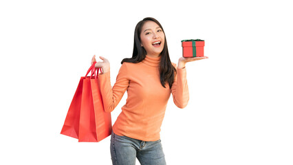 Happy Asian woman holding red shopping bags and gift box for Christmas and New Year holiday shopping.