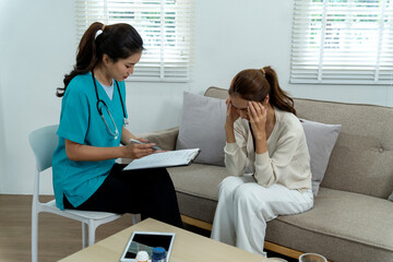Asian female doctor therapist consults adult patient woman stress anxiety mental health discussion offering support medical advice private clinic home visit.