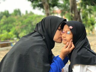 Mother Kissing Her Daughter&rsquo;s Cheek with Love