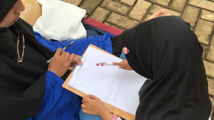 Muslim Mother Guiding Daughter&rsquo;s Outdoor Study Session